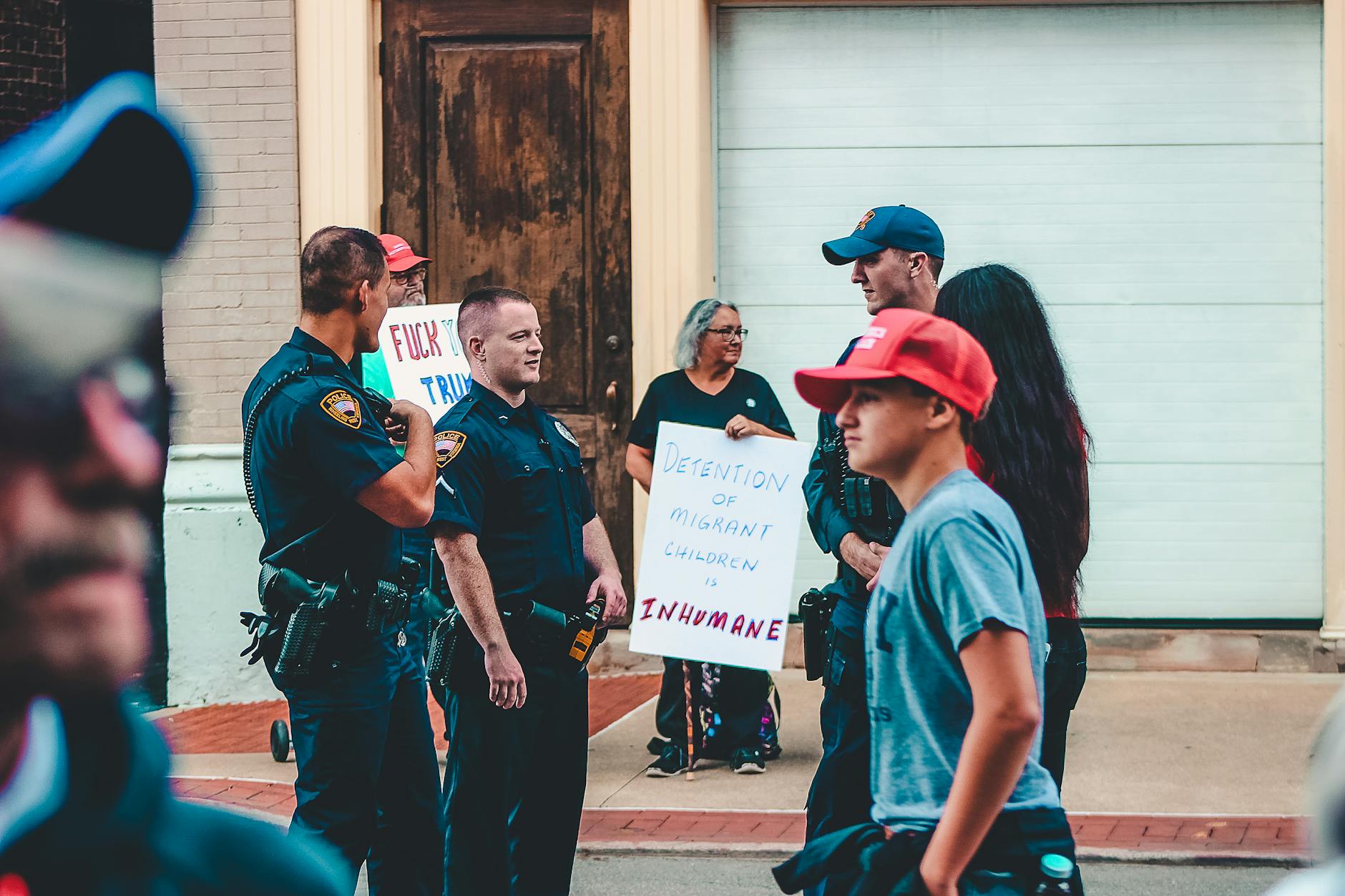 police standing near woman and man holding up signage